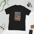 Black t-shirt printed with a vintage-style horror poster: a woman in a red raincoat and a man with a flashlight running along a pier at night past a lit Ferris wheel, a toothed shadow in the water, titled The Pier That Fed at Midnight