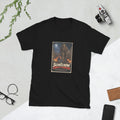 Black t-shirt printed with a horror movie poster of a tattered scarecrow walking down a muddy cornfield path lined with glowing jack-o'-lanterns, with a red barn and an empty wooden post under a full moon behind it, titled "The Scarecrow Counts to Thirteen."